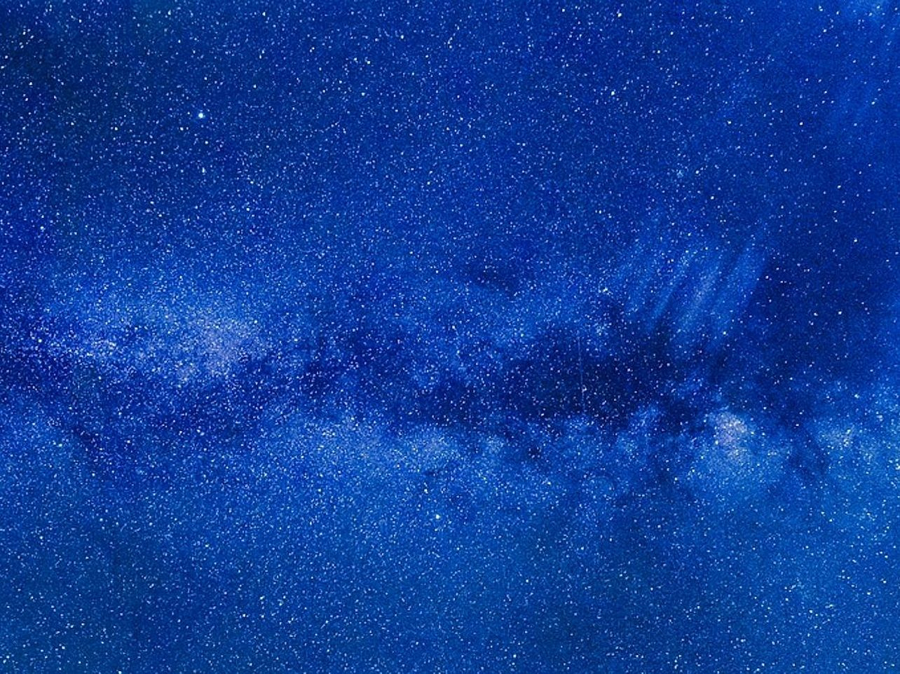 Reflection of stars on still water and distant hills